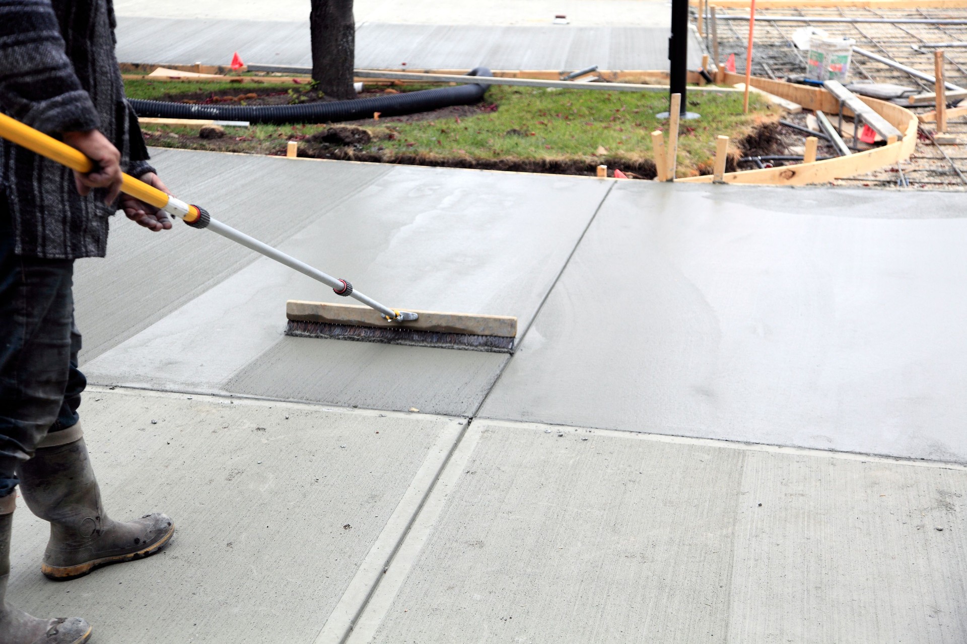 Smoothing And Finishing The New Concrete Driveway