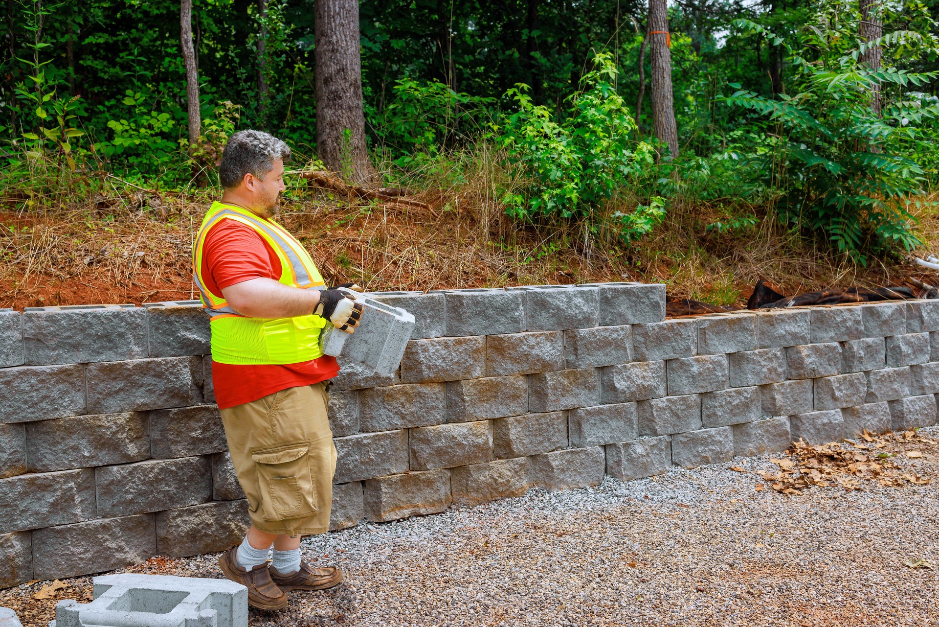 Construction worker mounting concrete block was perfectly aligned on the retaining wall.