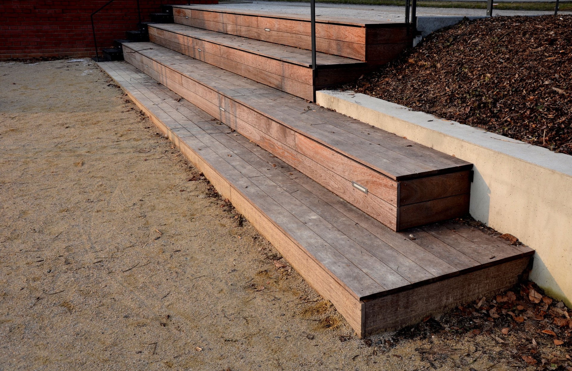 wooden staircase made of brown tropical wood in the park serves as benches of the theater amphitheater with built-in stair night safety scenic lighting